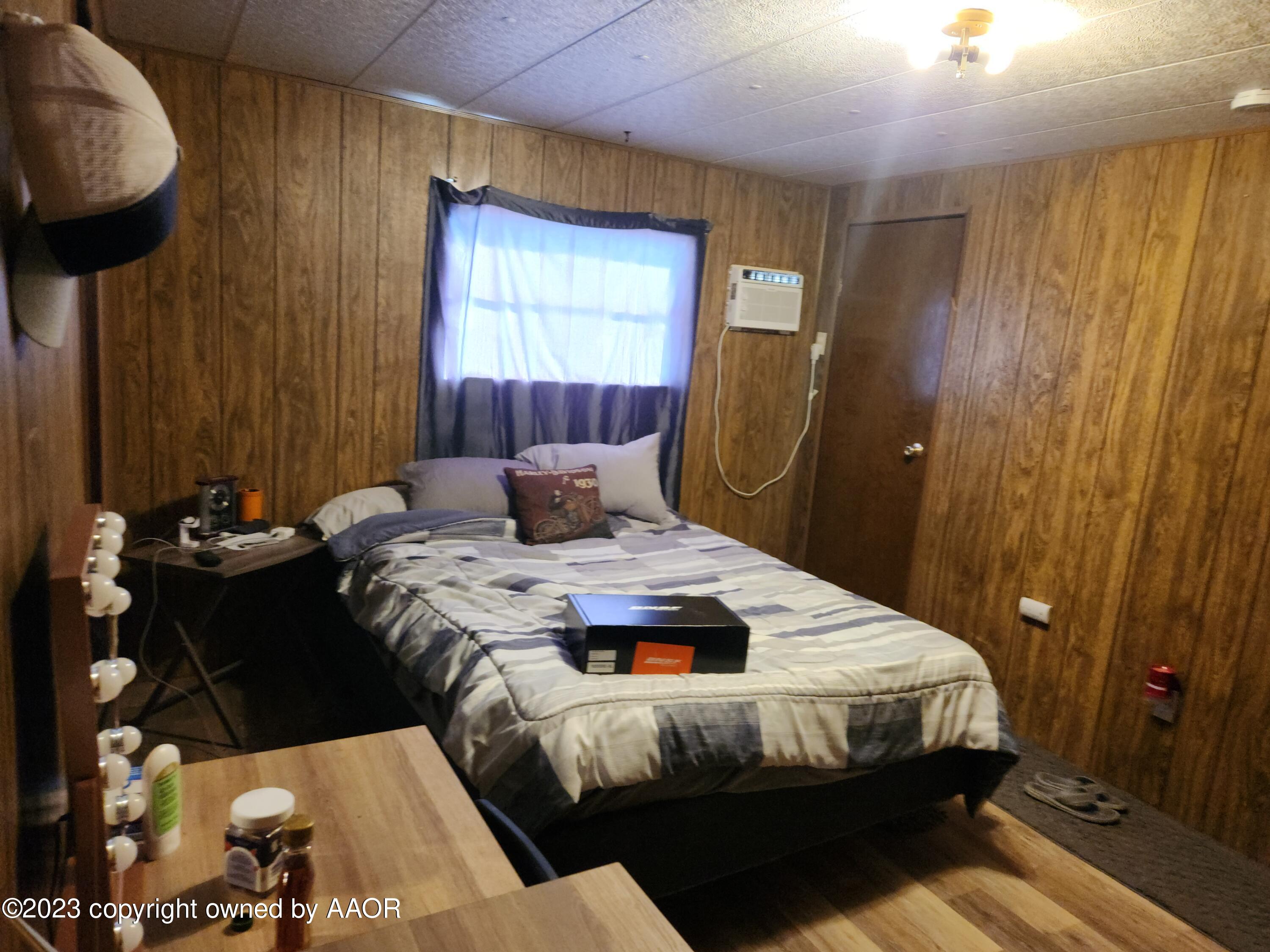 304 Collins Street Claude, TX 79019 - Photo 6 of 11 a bedroom with a bed and wooden floor