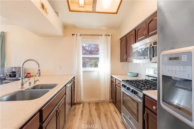 a kitchen with stainless steel appliances a sink a stove and a wooden floors