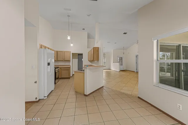 a view of a kitchen with furniture and refrigerator