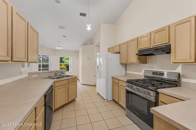 a kitchen with stainless steel appliances a sink stove and cabinets