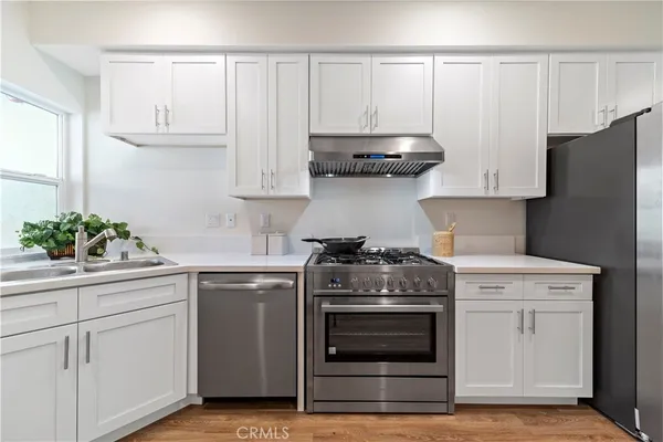 a kitchen with granite countertop white cabinets and stainless steel appliances