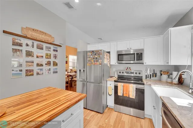 a kitchen with stainless steel appliances granite countertop a refrigerator and a stove top oven