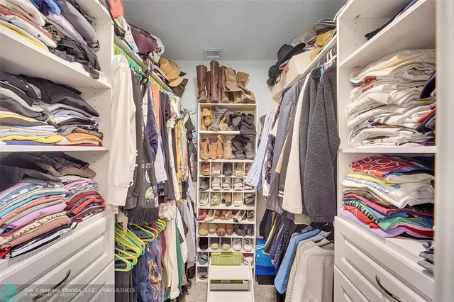 a view of walk in closet with clothes