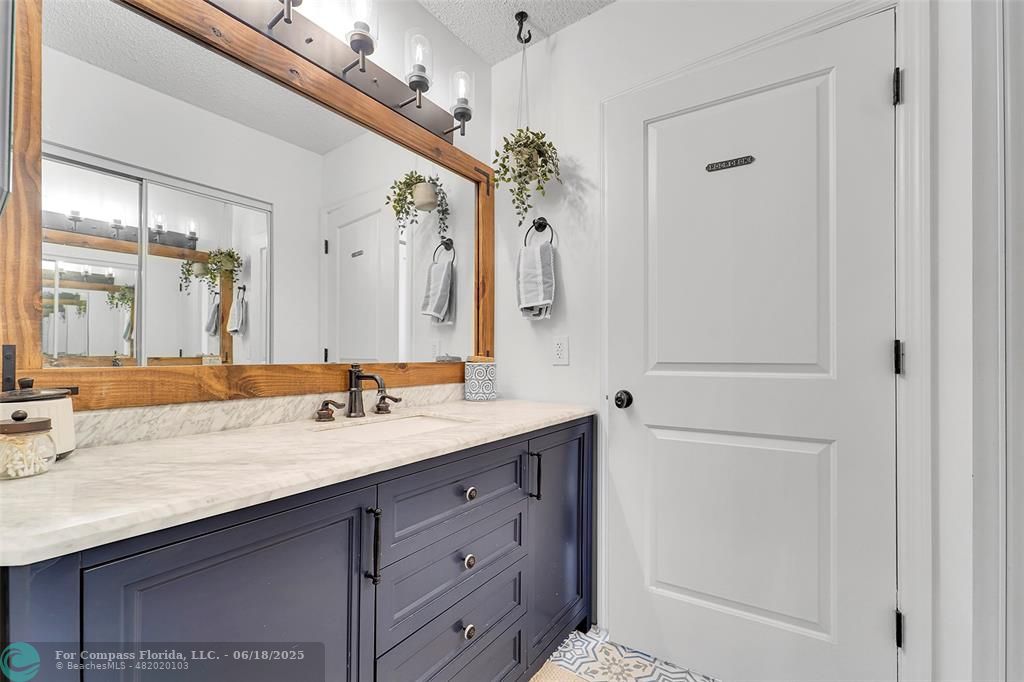 7542 Northwest 3rd Street Plantation, FL 33317 - Photo 20 of 31 a bathroom with a granite countertop sink a mirror and a shower