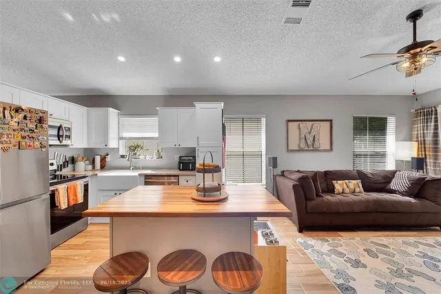 a living room with stainless steel appliances granite countertop furniture a couch and a window