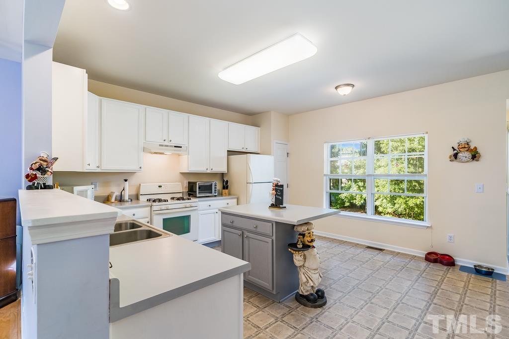 5145 Sandy Banks Road Raleigh, NC 27616 - Photo 12 of 30 a kitchen with a sink stove and white cabinets