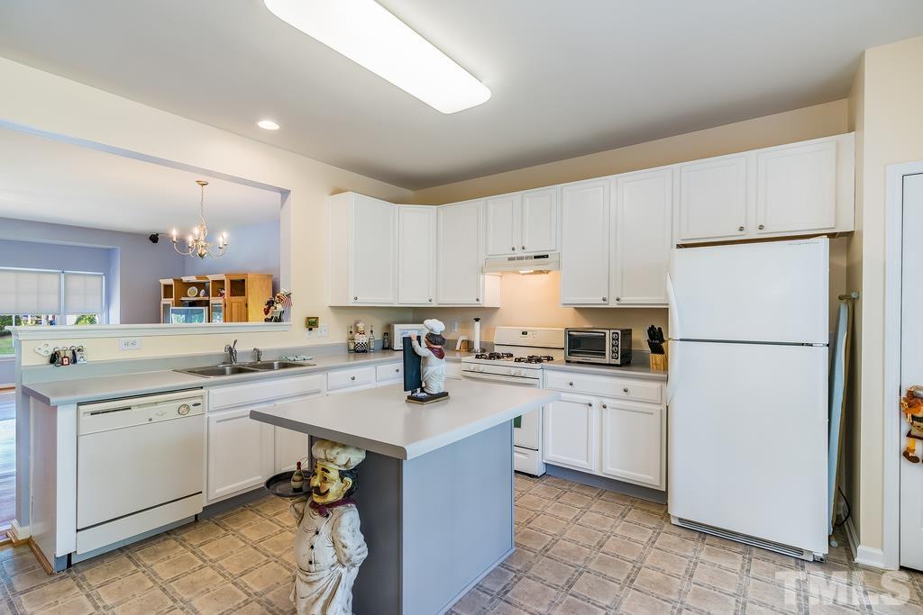 5145 Sandy Banks Road Raleigh, NC 27616 - Photo 13 of 30 a kitchen with a sink a stove a refrigerator and white cabinets