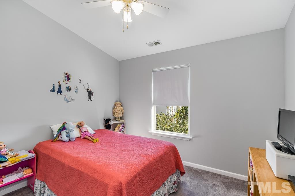 5145 Sandy Banks Road Raleigh, NC 27616 - Photo 18 of 30 a bedroom with a bed and a chandelier