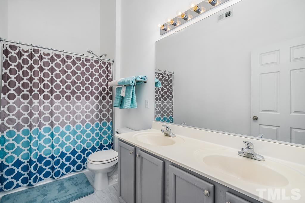 5145 Sandy Banks Road Raleigh, NC 27616 - Photo 22 of 30 a bathroom with a sink a toilet and shower