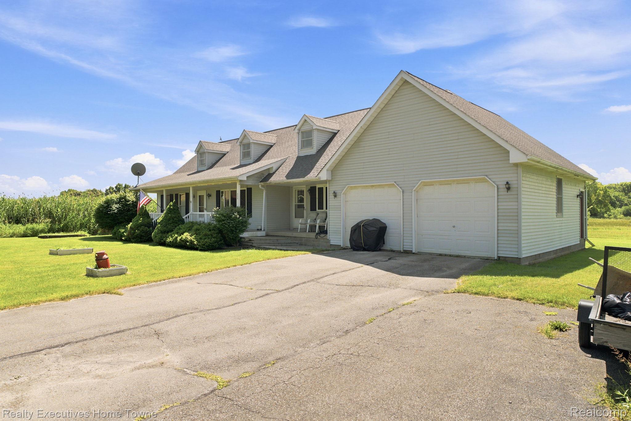 959 Braidwood Road Memphis, MI 48041 - Photo 11 of 58 Light-toned siding exterior with a covered front porch featuring white columns