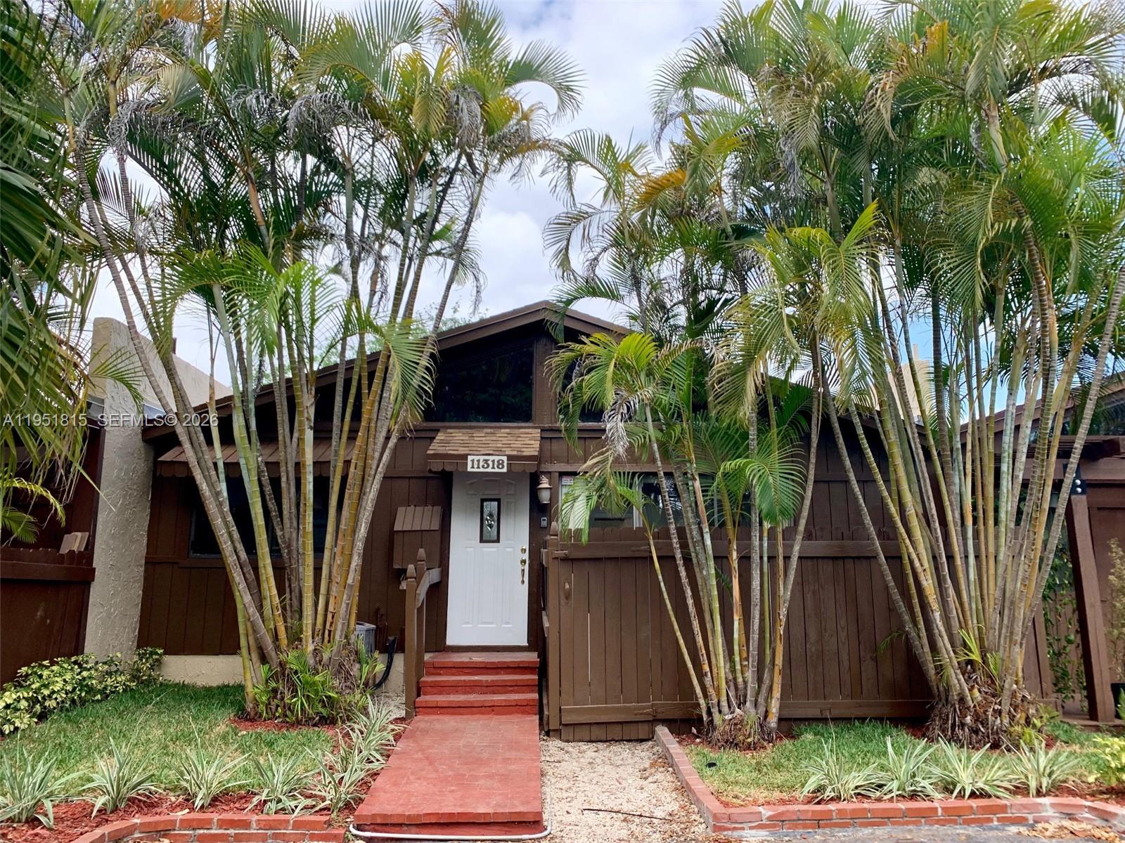 a front view of a house with a tree