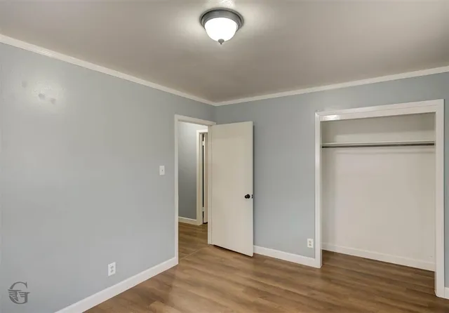 an empty room with wooden floor and closet