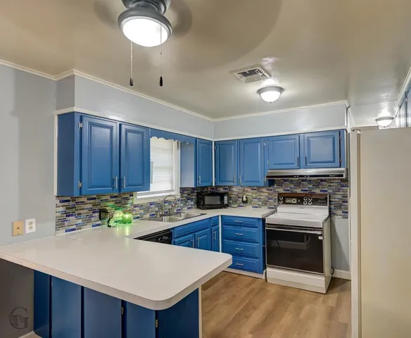 a kitchen with a stove sink and cabinets