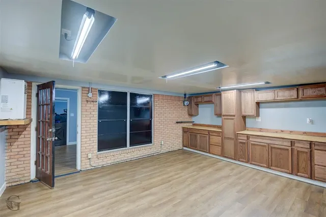 a large kitchen with cabinets wooden floor and stainless steel appliances