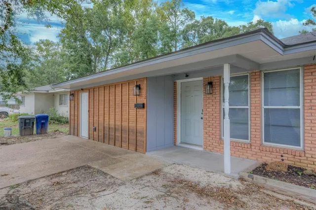 a view of a house with a patio and backyard