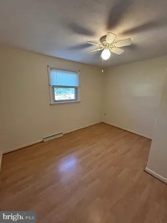 an empty room with a fan and a window