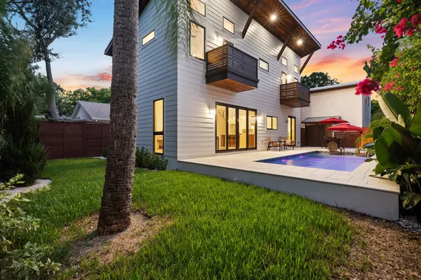 a view of a house with backyard and a tree