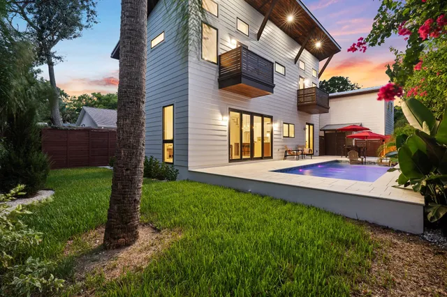 a view of a house with backyard and a tree