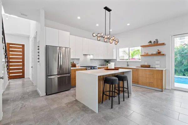 a kitchen with stainless steel appliances a table and chairs in it