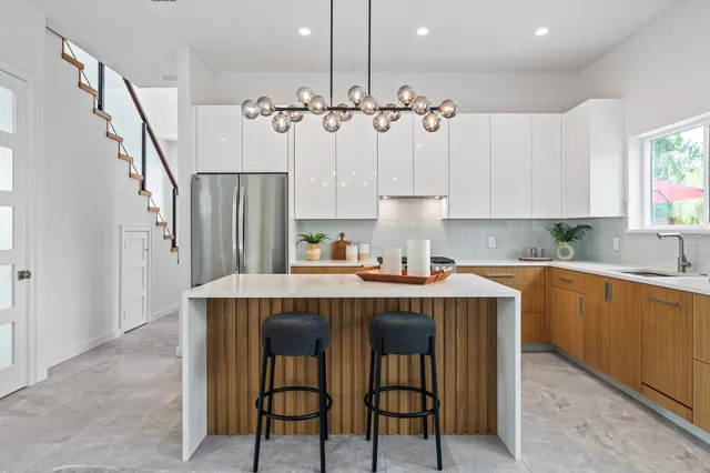 a open kitchen with stainless steel appliances kitchen island granite countertop a table and chairs in it