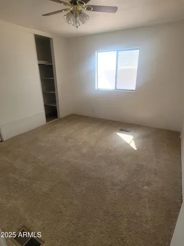 an empty room with windows and closet