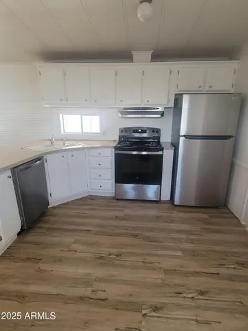 a kitchen with a refrigerator stove and white cabinets