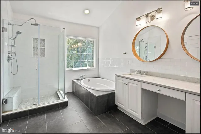 a bathroom with a double vanity sink mirror and bathtub