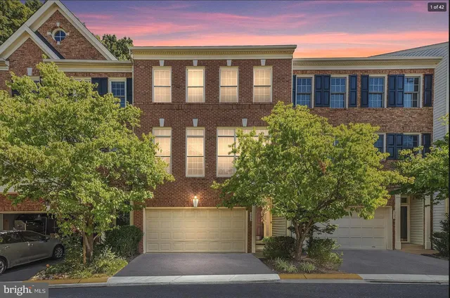 a front view of a house with a yard and potted plants