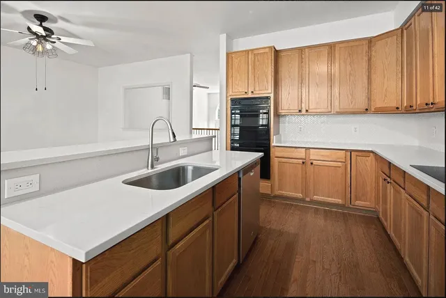 a kitchen with a sink dishwasher a stove and a refrigerator with wooden floor