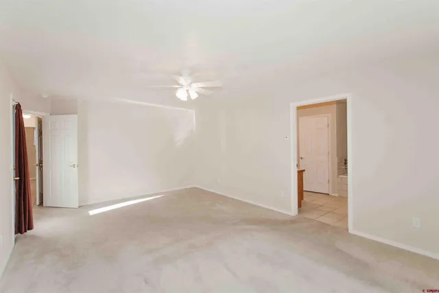 an empty room with a ceiling fan and a window
