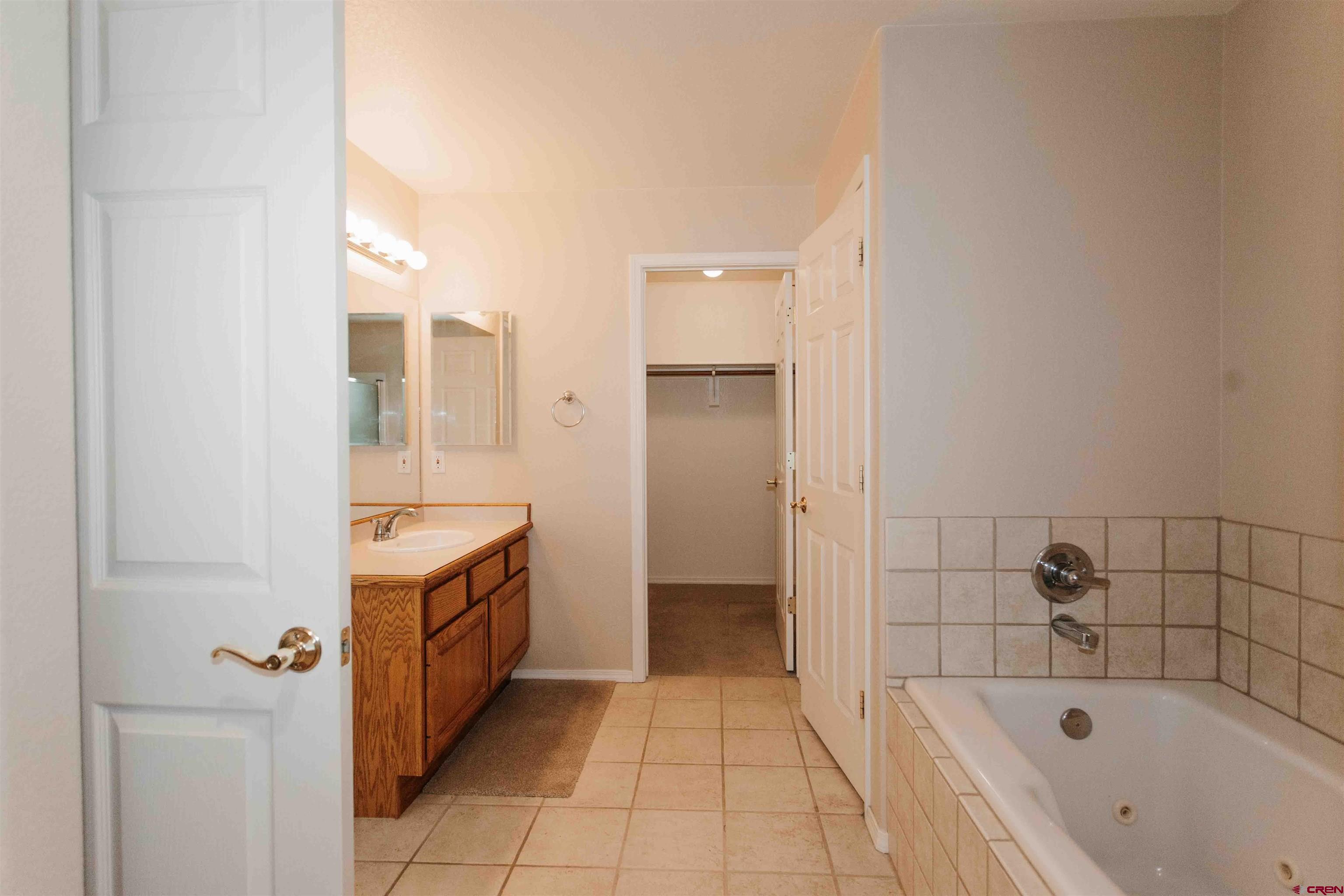2806 Bluebell Court Montrose, CO 81401 - Photo 14 of 37 a bathroom with a bathtub sink and mirror