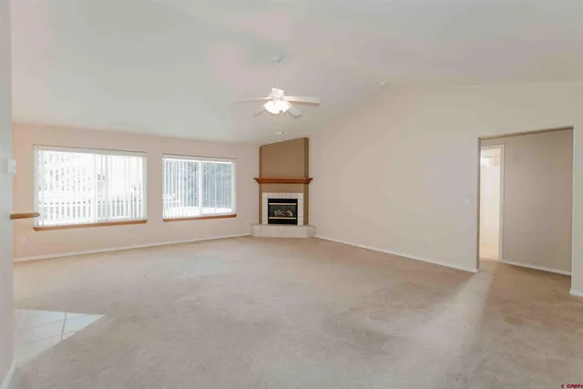 an empty room with a fireplace and windows