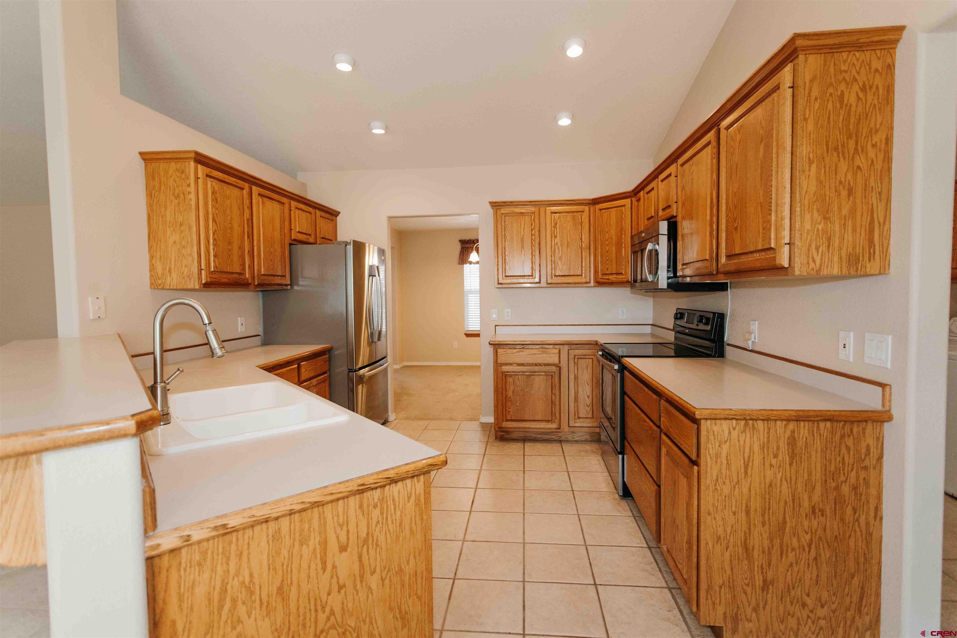 2806 Bluebell Court Montrose, CO 81401 - Photo 9 of 37 a kitchen with a sink a stove top oven and cabinets