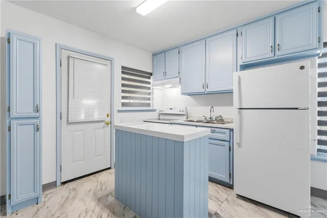 a kitchen with a refrigerator sink stove and cabinets