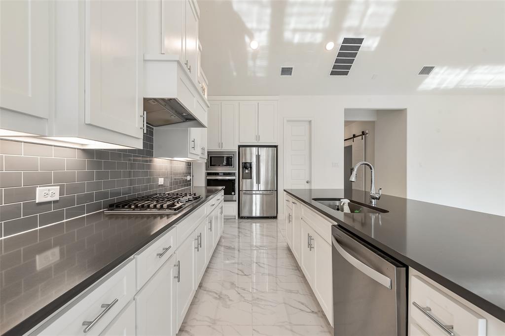 2714 Chambray Lane Mansfield, TX 76063 - Photo 16 of 32 a kitchen with stainless steel appliances granite countertop a sink a stove and a refrigerator
