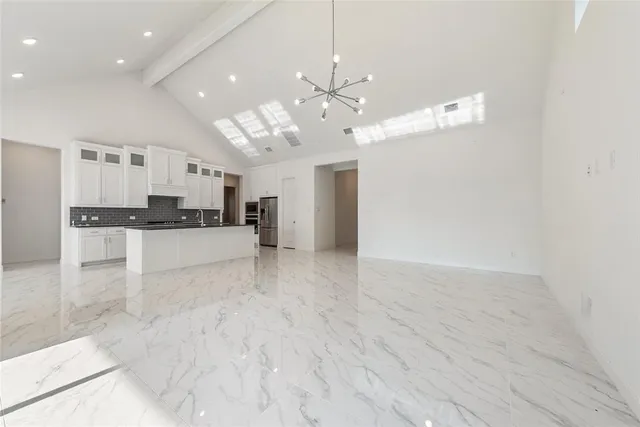 a view of a kitchen with a sink and refrigerator