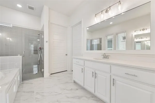 a spacious bathroom with a shower sink and mirror