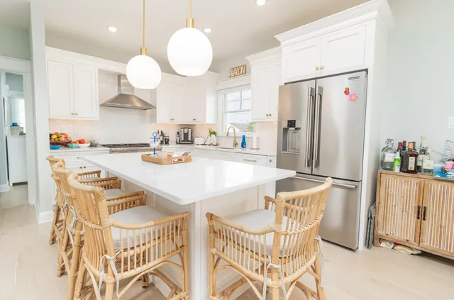 a kitchen with a dining table chairs refrigerator and cabinets