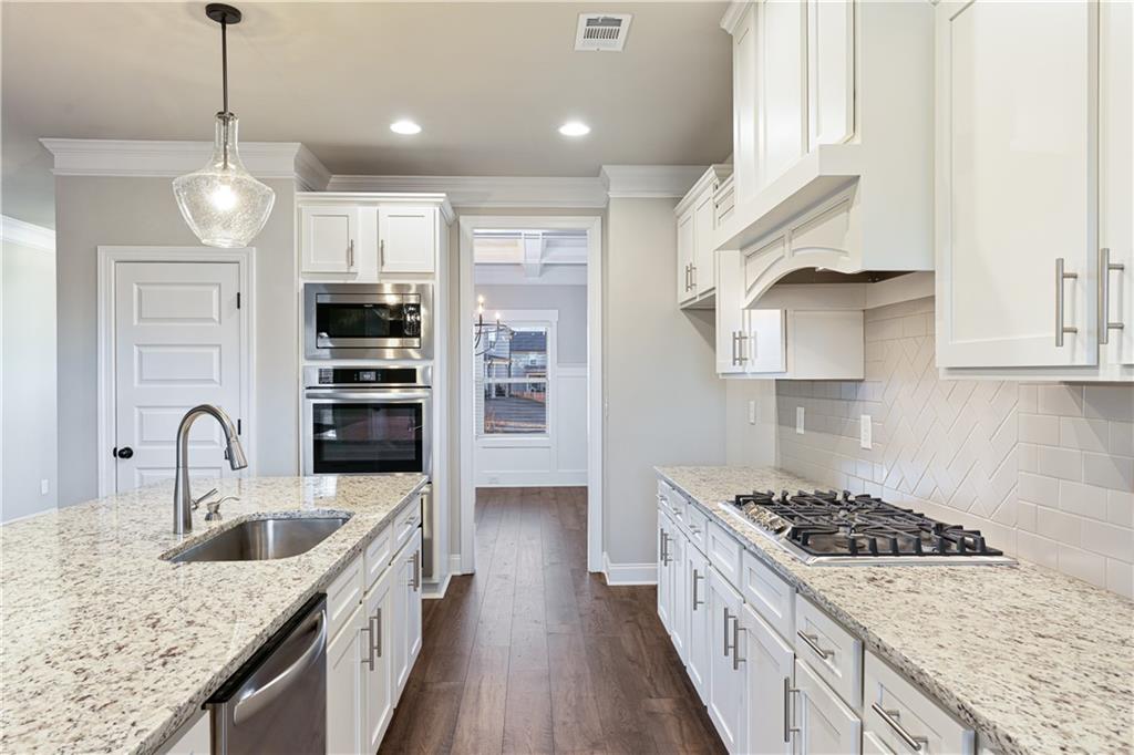 1647 Jasper Drive Winder, GA 30680 - Photo 12 of 16 a kitchen with stainless steel appliances granite countertop a sink stove and refrigerator