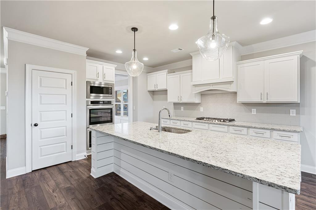 1647 Jasper Drive Winder, GA 30680 - Photo 13 of 16 a kitchen with kitchen island white cabinets and stainless steel appliances
