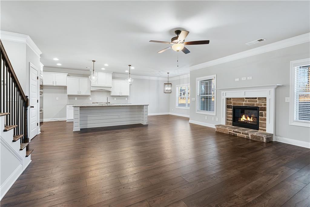 1647 Jasper Drive Winder, GA 30680 - Photo 14 of 16 a view of a kitchen with a stove wooden cabinets and a fireplace