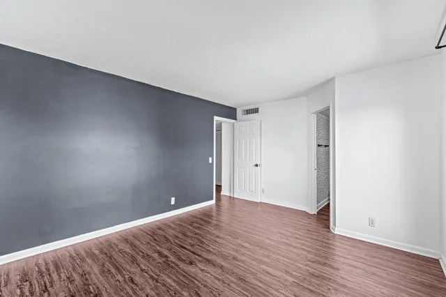 a view of an empty room with wooden floor