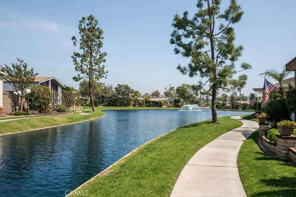 a view of a lake with a yard and large trees