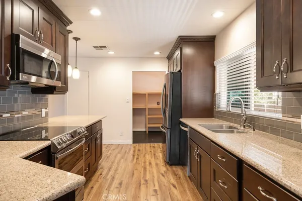 a kitchen with stainless steel appliances sink stove microwave and cabinets