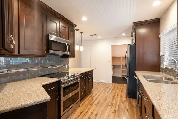 a kitchen with a sink stove and wooden cabinets