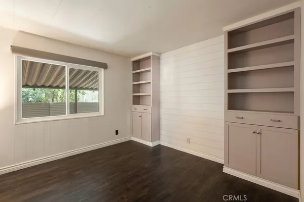 an empty room with wooden floor and a bathroom