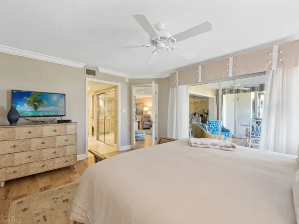 a bedroom with a bed and large windows