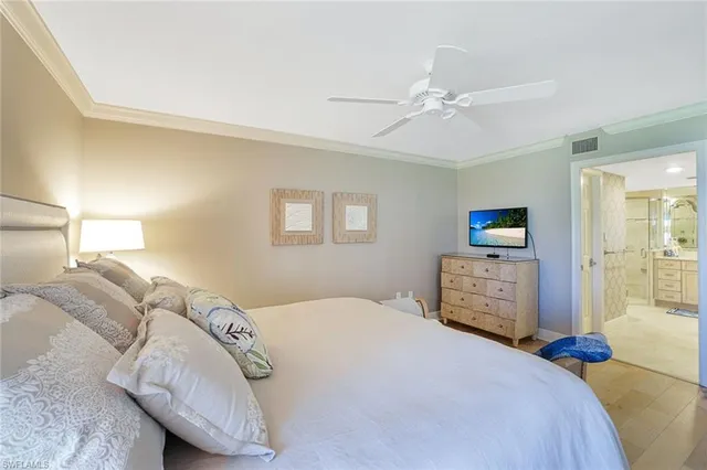 a bedroom with a large bed and a chandelier