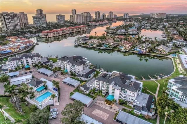 an aerial view of ocean and residential houses with outdoor space