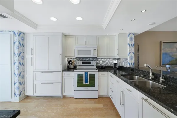 a kitchen with a sink dishwasher a stove and a refrigerator